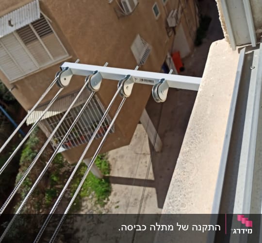 חבלי כביסה תלויים על גלגלות מתכת מחוץ לחלון